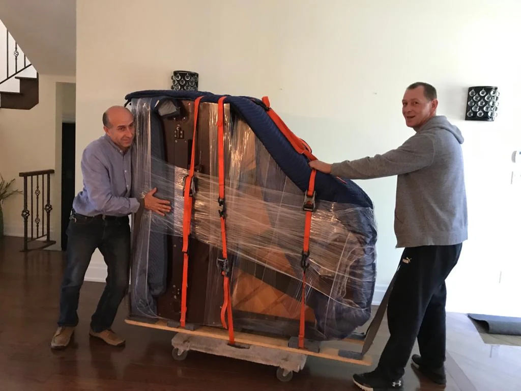 Toronto piano movers transporting wrapped upright piano