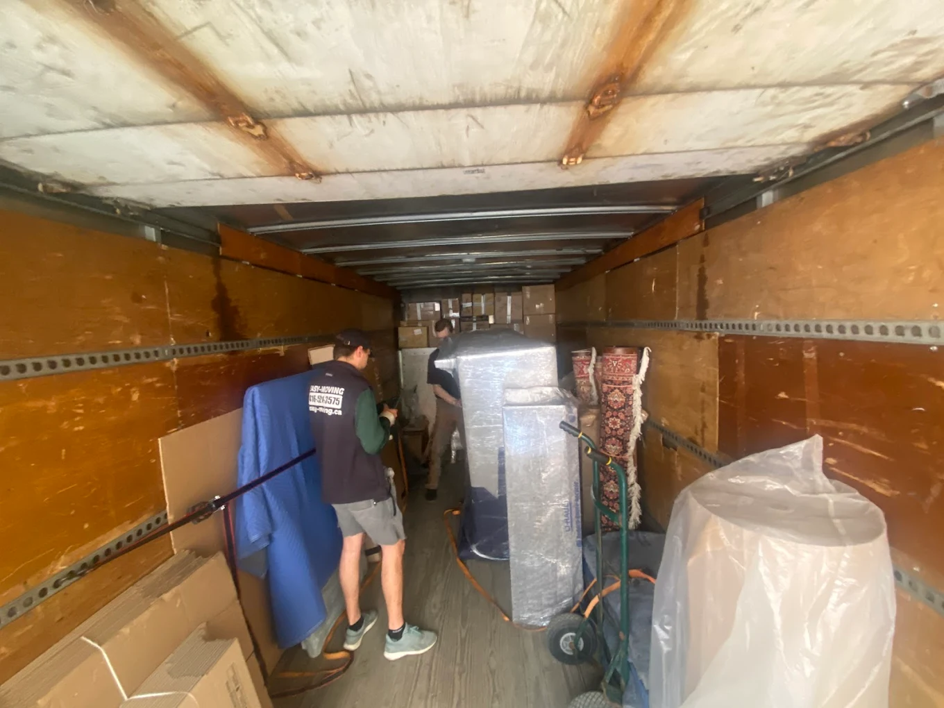 Movers efficiently packing items by volume inside a truck